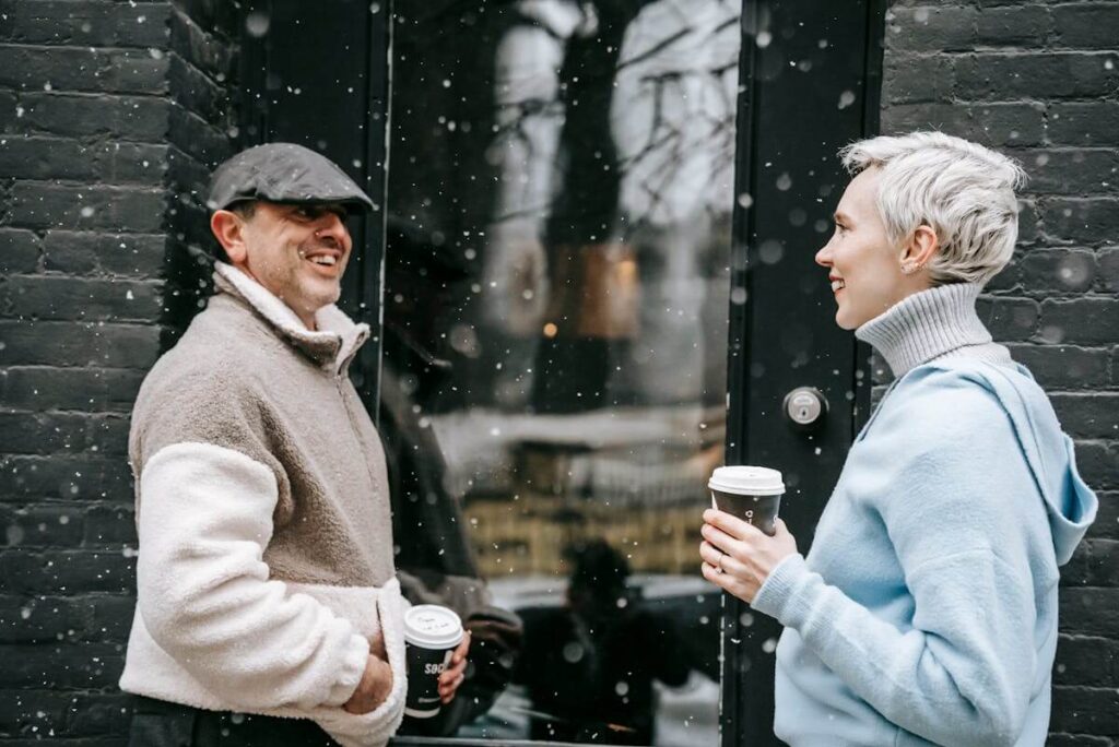 Two neighbors having a small talk next to the entrance to a cafe or house